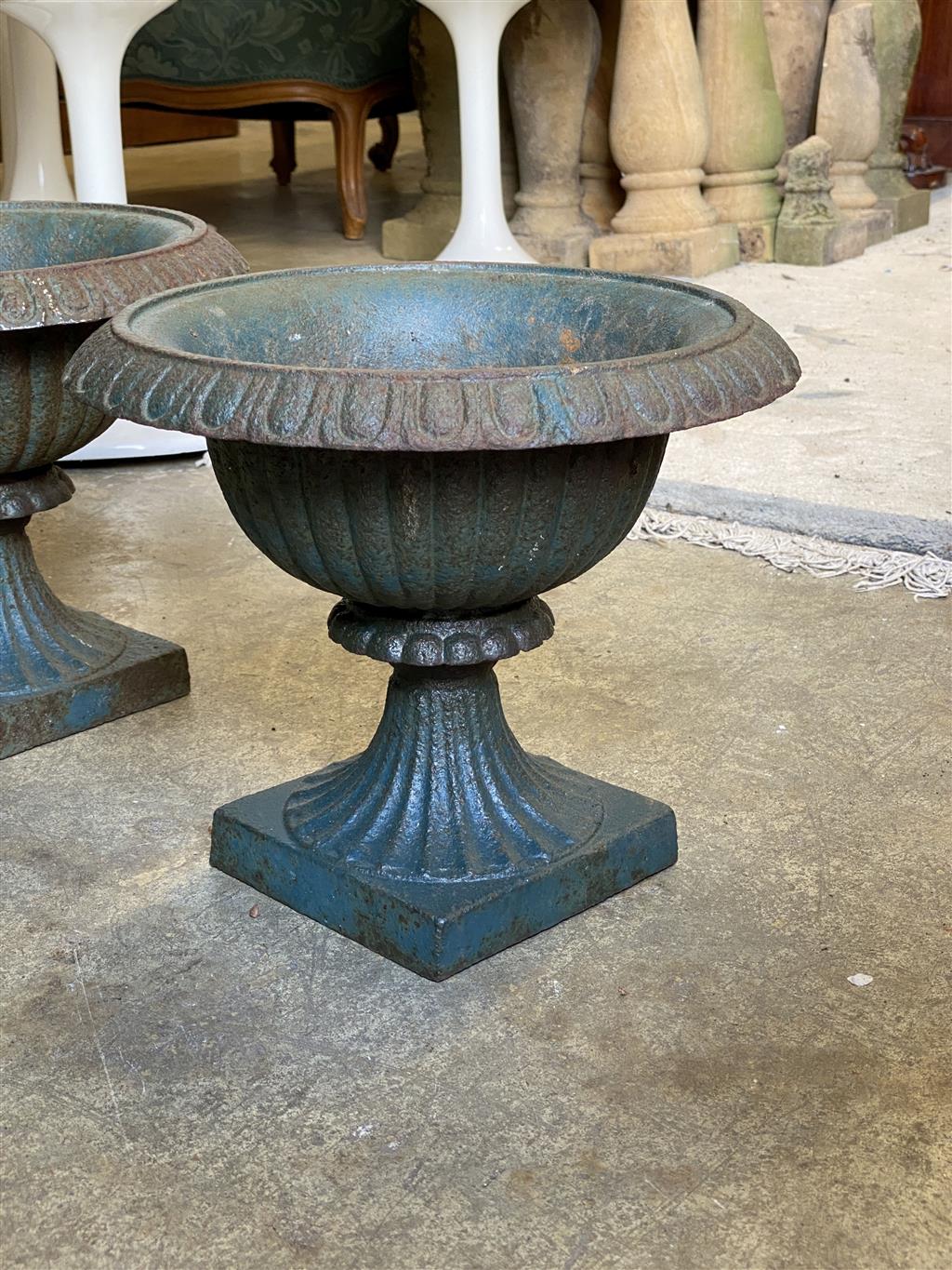 A pair of Victorian cast iron campana shaped garden urns, diameter 32cm, height 27cm